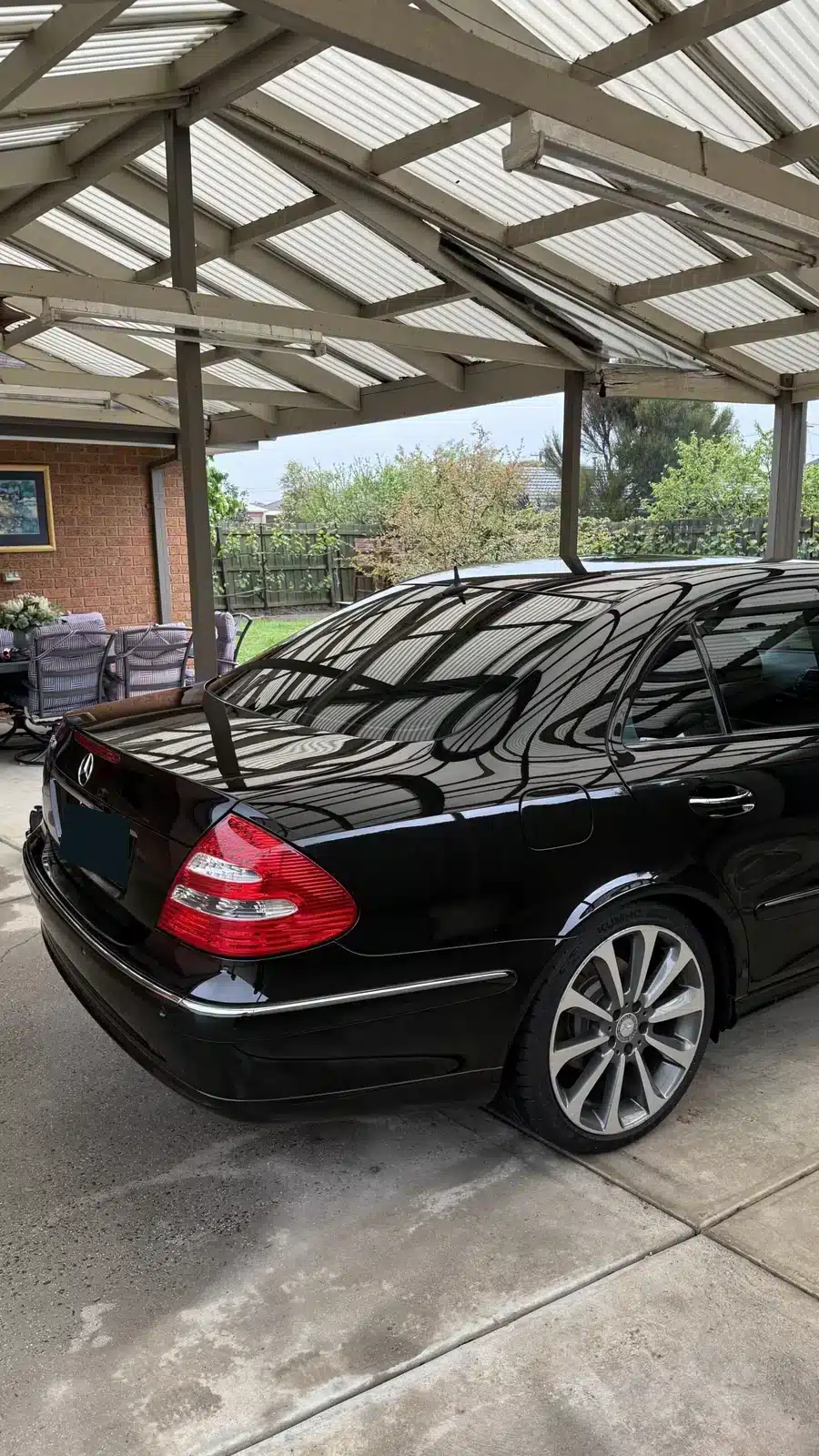 Black Mercedes rear-quarter paintwork after ceramic coating under a residential carport.