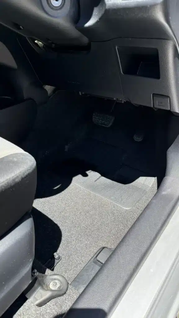 Matching Toyota Yaris passenger footwell and floor mat after interior cleaning.