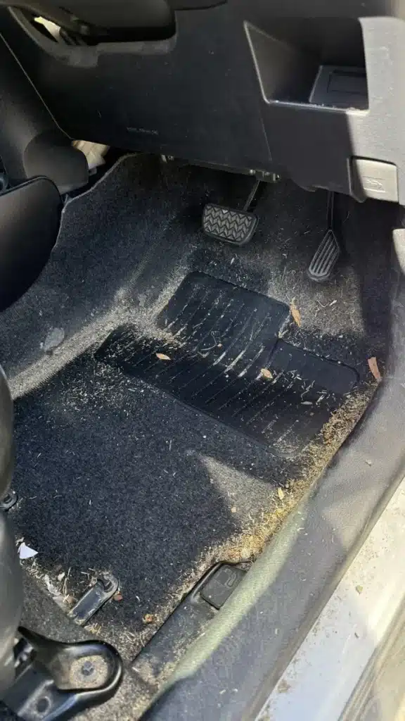 Toyota Yaris passenger footwell and floor mat before interior cleaning.